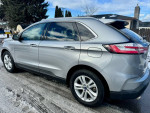2020 Ford Edge SEL FWD in silver, featuring clean exterior and all-weather tires, parked on a snowy road.