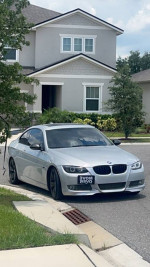 09 BMW 335i parked outside a house, featuring a clean design and recent upgrades, including new tires and performance parts.