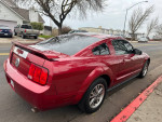 2005 Ford Mustang Deluxe RWD parked on the street, showcasing its clean exterior and sporty design.