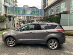 2013 Ford Escape SEL FWD in Sterling Gray Metallic parked with modern buildings in the background