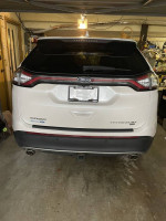 Rear view of a 2016 Ford Edge Titanium in a garage, well-maintained, showcasing luxury features and low mileage.
