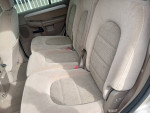 Interior view of a clean 2004 Ford Explorer with third row seating and tan upholstery.