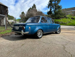 1970 BMW 1600 2002 modified classic car parked outdoors with scenic background.