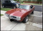 1967 Pontiac Firebird in red color parked outside, featuring aftermarket wheels and no visible rust or dents.