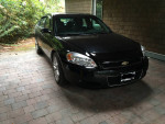 2007 Black Chevrolet Impala SS parked in a driveway, featuring a sleek design and well-maintained condition.