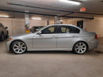 2006 BMW 330i parked in a garage, showcasing its sleek design and alloy wheels, well-maintained with service records.