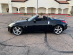 2008 Nissan 350Z convertible in black with clean title and low mileage, parked on a road.