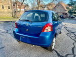 2007 Toyota Yaris hatchback in excellent condition, blue color, showing rear view, 62,000 miles.