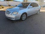 2006 Toyota Avalon XLS FWD in silver, parked, showcasing clean exterior and stylish design with sunroof.