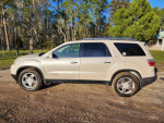 2008 GMC Acadia in pearl white with black leather interior, parked outdoors with trees in background.