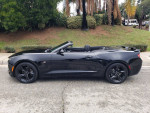 2017 Chevrolet Camaro 2LT Convertible in black, parked with a scenic backdrop of palm trees.
