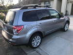 2011 Subaru Forester in silver, featuring AWD, winter package, and clean condition, parked in a residential area.
