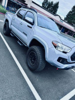 2021 Toyota Tacoma SR5 4WD in cement color, parked, showcasing its off-road style and features.