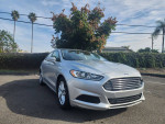2014 Ford Fusion SE in silver with black interior and alloy wheels, parked outdoors.