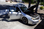 2008 Subaru Impreza WRX in silver with open hood and custom rims parked outside