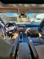 Interior view of a 2013 Land Rover Range Rover Sport showcasing leather seats and dashboard features.