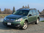 2013 Subaru Outback in green parked near the river, showcasing its clean exterior and modern design.