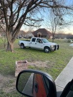 2004 Ford F350 Super Duty pickup truck parked in a yard, featuring a 6.0 Power Stroke engine.