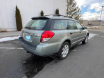 2009 Subaru Outback in gray color parked, showcasing its all-wheel drive and manual transmission features.