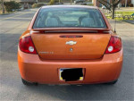 Rear view of a 2005 Chevrolet Cobalt LS in orange, showcasing its sleek design and features.