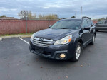 2013 Subaru Outback 2.5L Premium in a parking lot, showcasing its clean title and all-wheel drive feature.