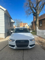 Front view of a 2013 Audi A4 in white, showcasing its design and clean condition, parked outside.