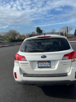 2014 Subaru Outback with low mileage parked, showcasing clean exterior and all-wheel drive features.
