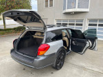 2005 Subaru Outback showing spacious interior and trunk, all-wheel drive, and clean title with 99,000 miles.