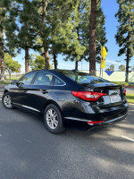 2015 Hyundai Sonata Eco FWD parked near trees, showcasing sleek design and alloy wheels, 68,000 miles