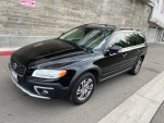A sleek black 2015 Volvo XC70 parked on the street, showcasing its modern design and clean condition.