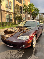 2000 Mazda Miata Special Edition in burgundy color, parked outdoors near apartment buildings.
