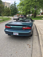 1995 Chevrolet Camaro Z28 convertible in mystic teal parked on a street, featuring original condition and low mileage.