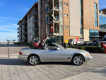 2000 Mercedes-Benz SL500 convertible parked in a modern urban setting with a raised soft top.