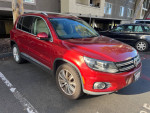 2014 Volkswagen Tiguan SEL 4Motion in red, showcasing clean design and sporty features parked in a lot.
