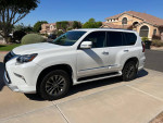 2019 Lexus GX 460 in white, parked on a driveway, showcasing its luxury design and sporty features.