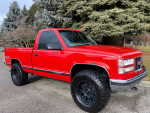 1997 GMC Sierra 1500 SL 4WD truck with red exterior and black wheels parked outdoors