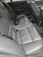 Interior of 2007 BMW 335i showing the backseat area with leather upholstery and seat belts.