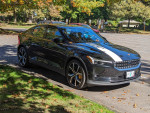2021 Polestar 2 AWD Long Range parked with white vinyl stripe under autumn trees.