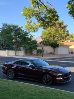 2018 Ford Mustang EcoBoost in maroon color parked outside, showcasing its sporty design.