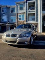 2010 BMW 3 Series 335i in excellent condition, sporty sedan with low mileage parked in front of apartments.