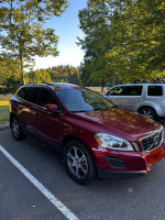 2011 Volvo XC60 T6 in red parked in a scenic area, showcasing great condition and clean exterior.