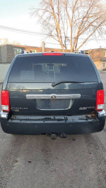 Rear view of a Chrysler Aspen SUV with a tow package and minor rust spots for sale.