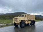 1985 BMY M931A2 military truck parked on a road with mountains in the background, showing off clean exterior and robust tires.