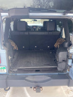 Interior view of 2012 Jeep Wrangler Unlimited Rubicon showing rear seating and storage space.