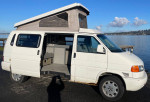 1999 Volkswagen EuroVan camper with pop-top and outdoor view, perfect for road trips.