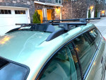 2006 Subaru Forester roof with Yakima crossbars for cargo transport, parked in a residential area.