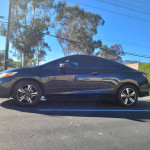 Side view of a 2015 Honda Civic EX in black, parked under clear blue skies