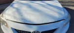Close-up of 2010 Toyota Corolla LE hood showing minor paint damage and wear