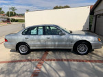 1999 Toyota Avalon XLS in silver parked outside, showcasing its well-maintained exterior and alloy wheels.