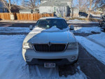 Front view of 2004 Lincoln Aviator Luxury AWD parked in snow, showcasing its Ceramic White Tri-Coat exterior.